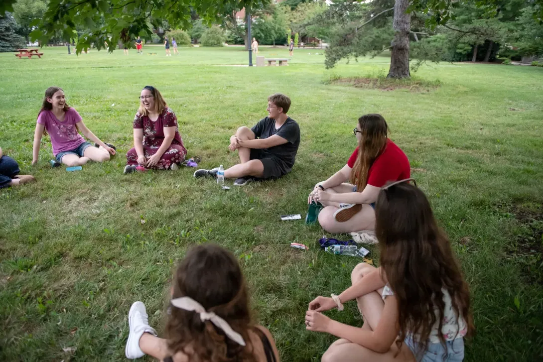 Student at honors ice cream social sitting in a circle on the Quad